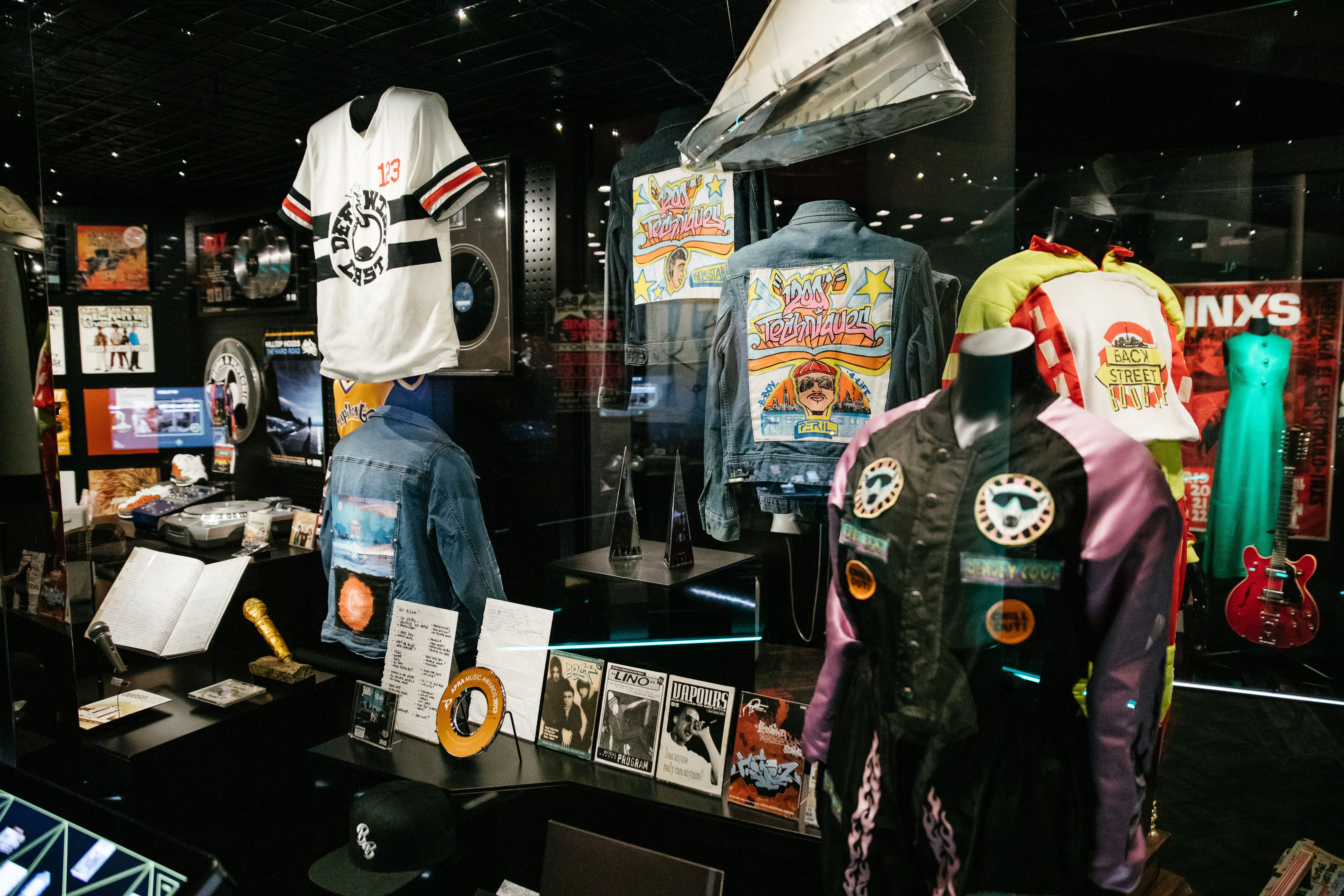 The Hip Hop display case at the Australian Music Vault, featuring jackets, t-shirts and possessions from Australian Music hip hop artists. 