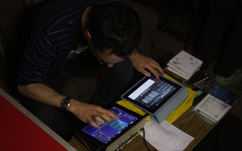A man sitting down making adjustments on two digital screens. 