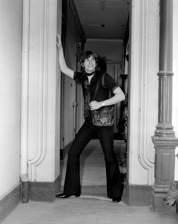 Ronnie Burns, c.1970, standing and smiling in the open doorway of a terrace house.