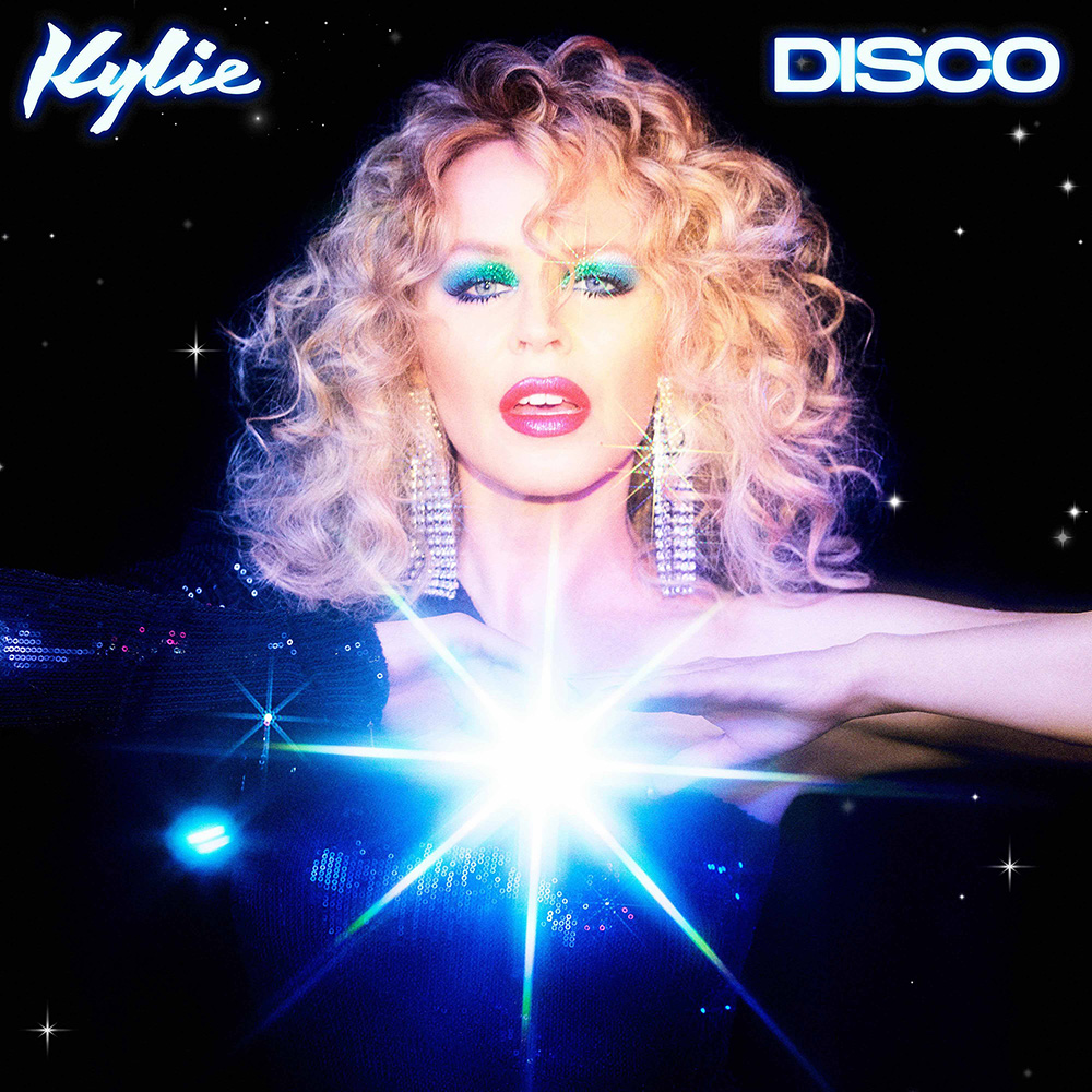 The cover of Kylie Minogue's album 'Disco' showing Kylie's face sitting on top of a sunburst, against a space background.